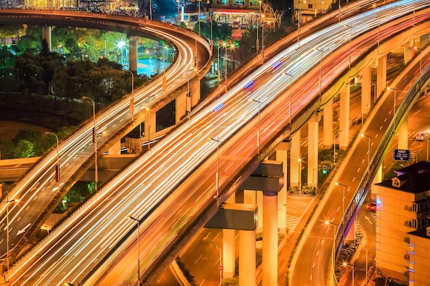 Closeup of the flyover at night busy traffic with light trailsxA