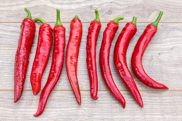 Closeup fresh red hot peppers on the wooden background Top view