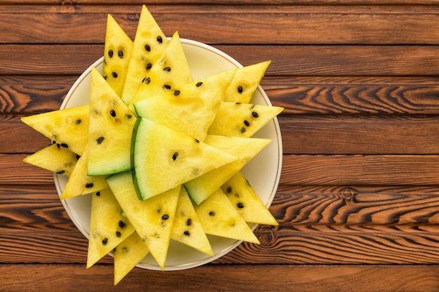 Closeup of fresh yellow watermelon slices on white plate