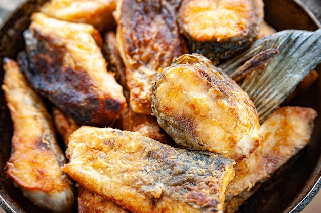 Closeup of fried fish in a frying pan Street food fast food concept