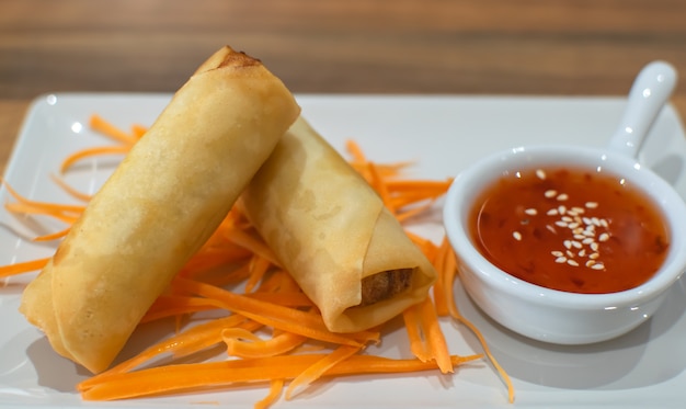 Closeup fried spring roll with sweet chili sauce in white plate