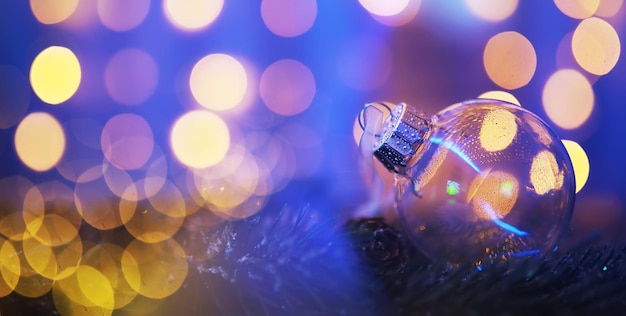 Closeup of glass Christmas ball on abstract light background.