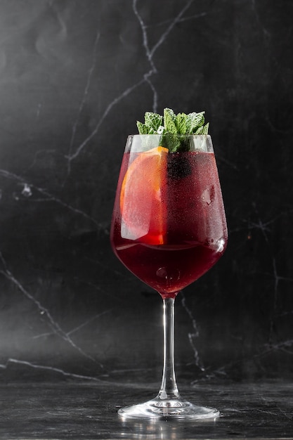 Closeup glass of red wine fresh sangria at bright bar counter background.