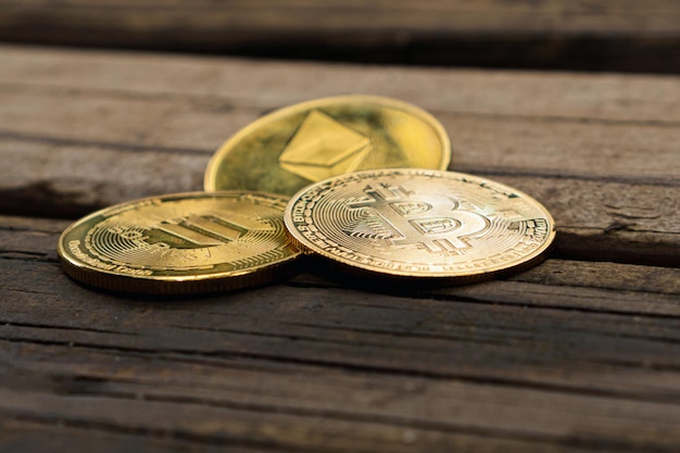 Closeup of golden Bitcoin Ethereum and Solana coins on a rustic wooden table Cryptocurrency currency Financial market Selective focus