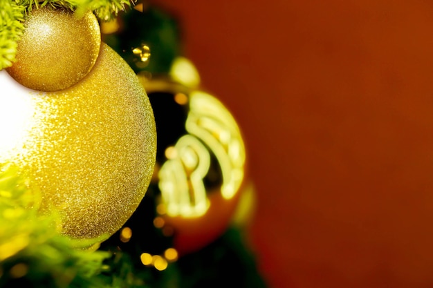 Closeup golden Christmas Balls Decorated on Pine Tree on Christmas day and red background