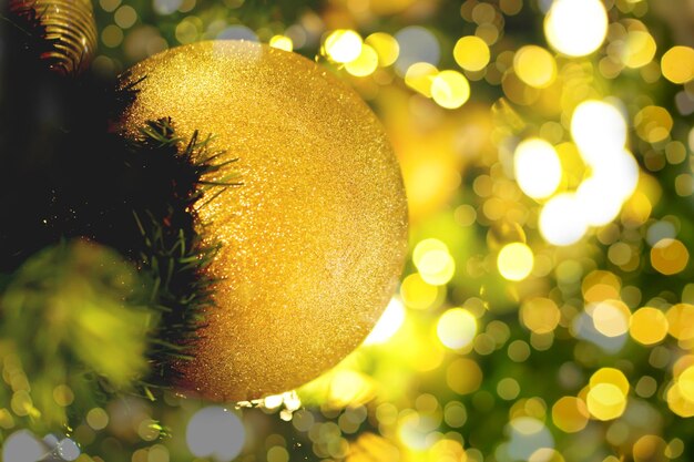 Closeup golden Christmas Balls Decorated on Pine Tree on Christmas day with blurry background