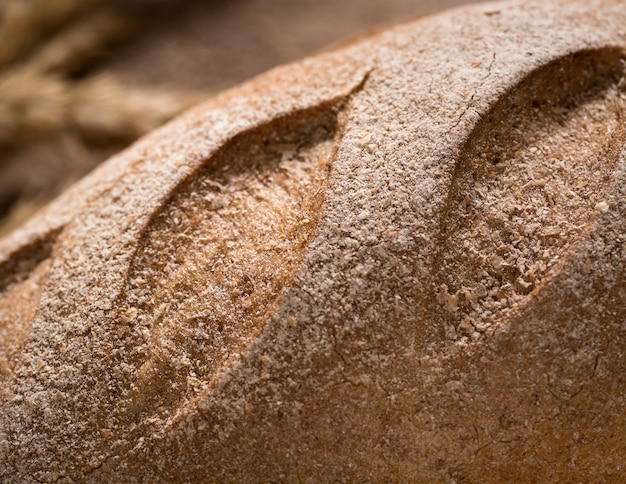 Closeup of Golden and loaf of fresh bread