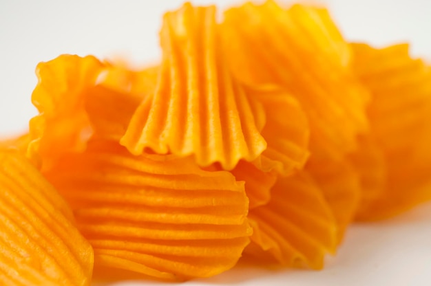 Closeup golden yellow sweet potato chips white background