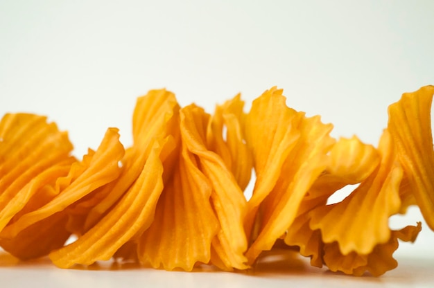 Closeup golden yellow sweet potato chips white background