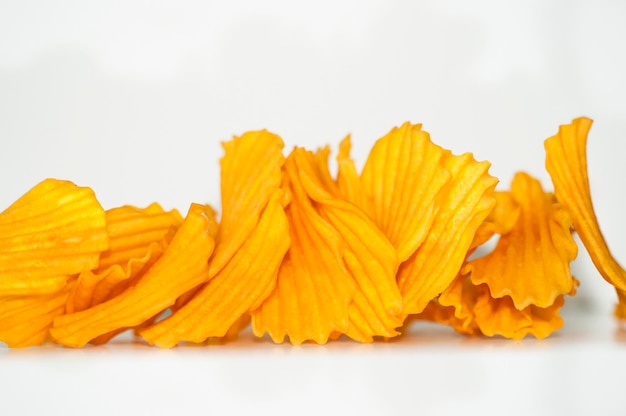 Closeup golden yellow sweet potato chips white background