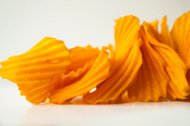 Closeup golden yellow sweet potato chips white background