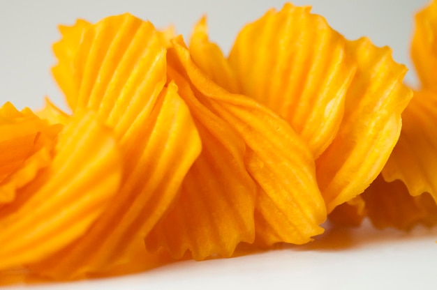 Closeup golden yellow sweet potato chips white background