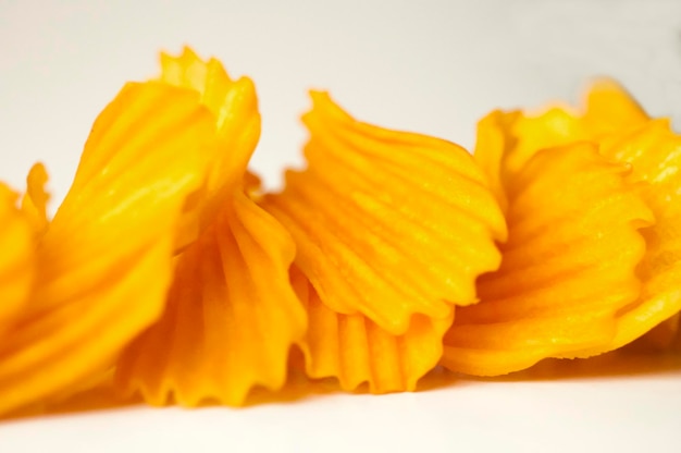 Closeup golden yellow sweet potato chips white background