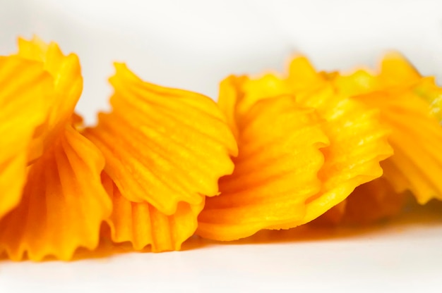 Closeup golden yellow sweet potato chips white background