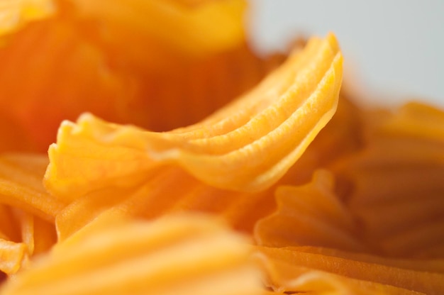 Closeup golden yellow sweet potato chips white background