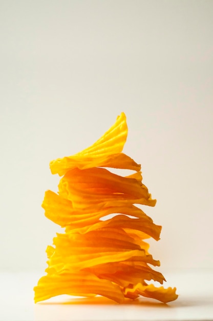 Closeup golden yellow sweet potato chips white background