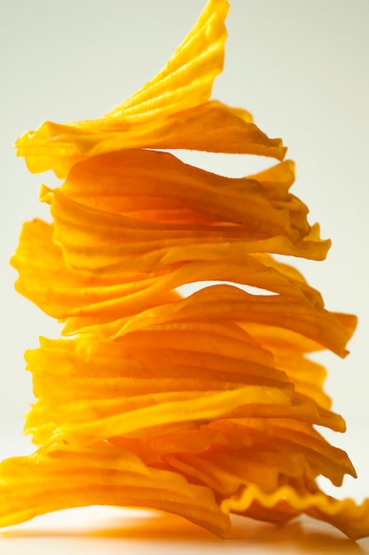 Closeup golden yellow sweet potato chips white background