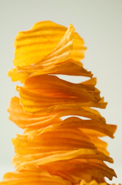 Closeup golden yellow sweet potato chips white background