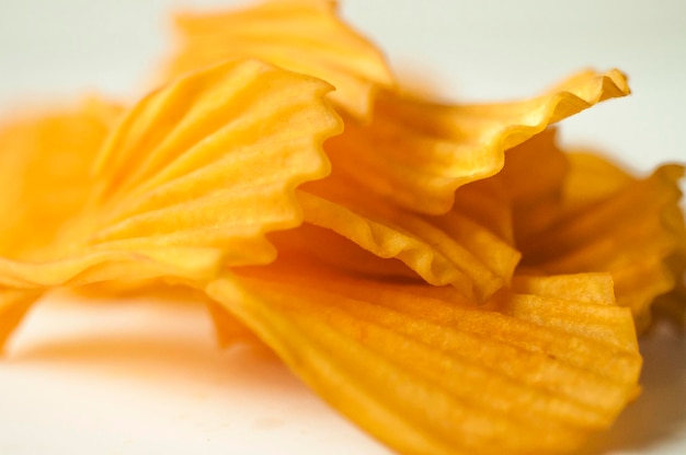 Closeup golden yellow sweet potato chips white background