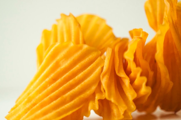 Closeup golden yellow sweet potato chips white background