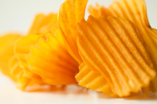 Closeup golden yellow sweet potato chips white background