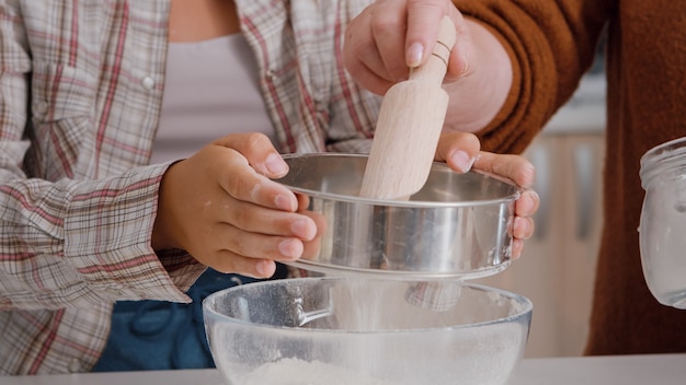 Closeup of grandchild strain flour ingredient in kitchen bowl preparing homemade cookie dough