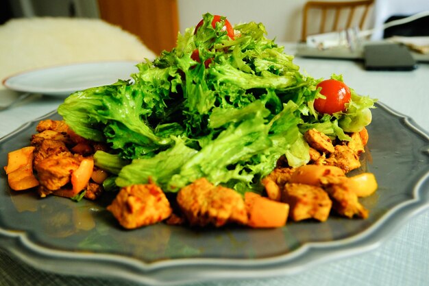 Closeup of green lettuce with chicken slice on a plate