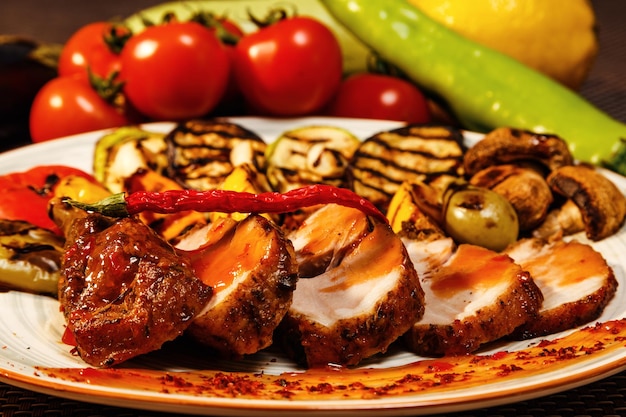 Closeup of grilled tasty meat served with sauce and pepper