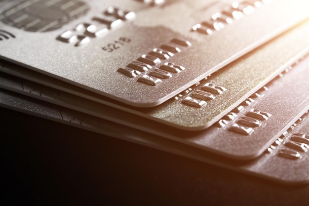 Closeup of a group of bank credit cards on dark background with sunlights