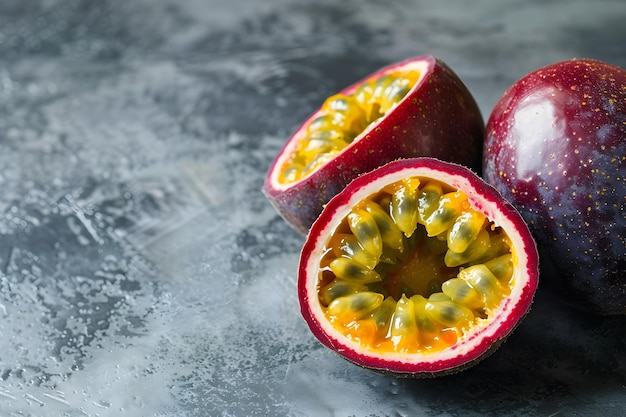 Photo closeup of halved passion fruit and whole passion fruit on a gray surface