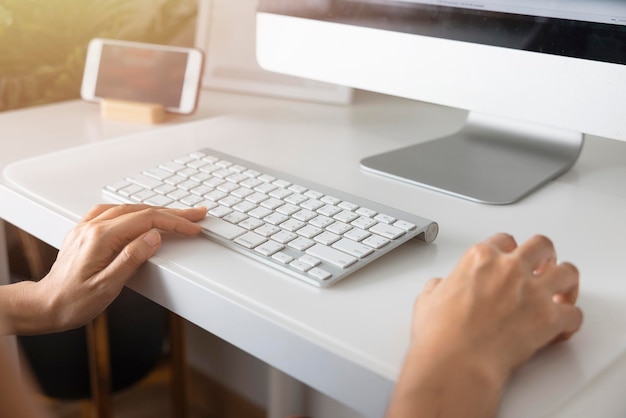 Closeup hand of Asian woman working office worker typing on keyboard at home office