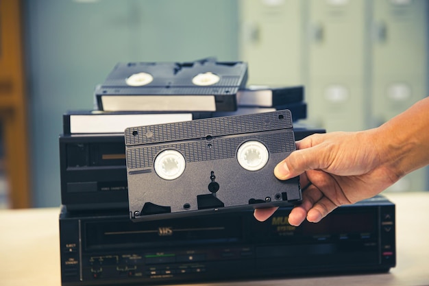 Closeup hand chooses video cassette tape