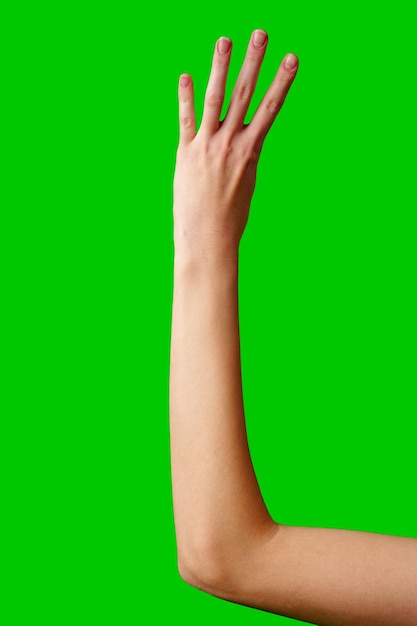 Closeup of a hand gesturing four against a green background