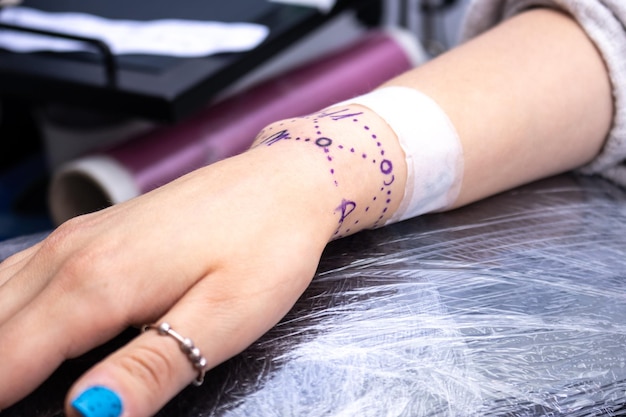 Closeup of the hand of a girl getting a tattoo problems caused by tattoos