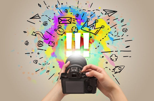 Photo closeup of a hand holding digital camera with abstract drawing concept concept