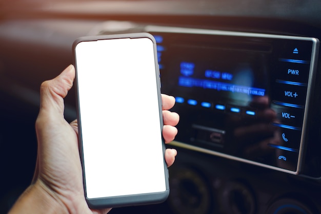 Closeup hand holding a smartphone and the bluetooth is connected, playing music in the car.