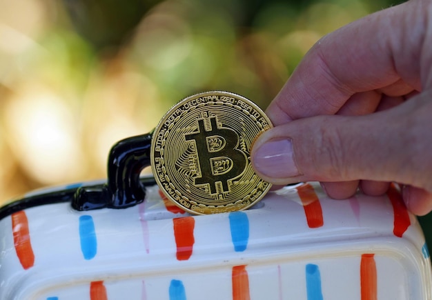 Closeup of a hand holding yellow coin with a bitcoin sign