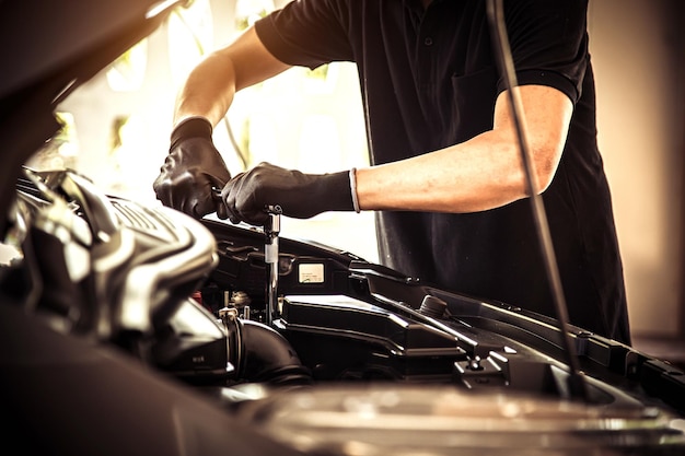 Closeup hand mechanic using the wrench to repairing car