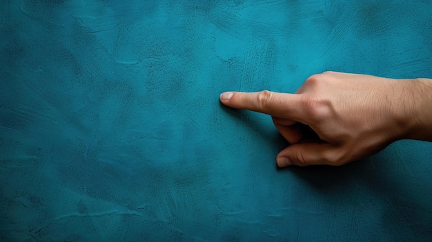 Closeup of a hand pointing on a blue textured background