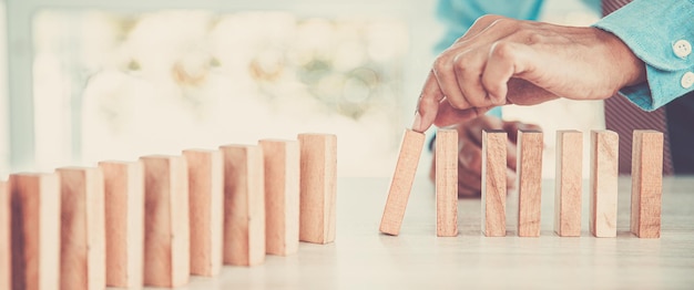 Closeup hand prevents wooden block not falling