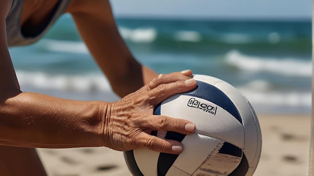 closeup of the hand of a woman 55 years old who holds a volleyball against the backdrop of a summer beach and the ocean