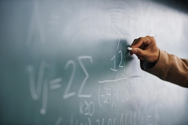 Closeup hand and writing on a blackboard formula and teaching with system process and geek Zoom person and teacher with chalk learning and maths equation with calculation research or education