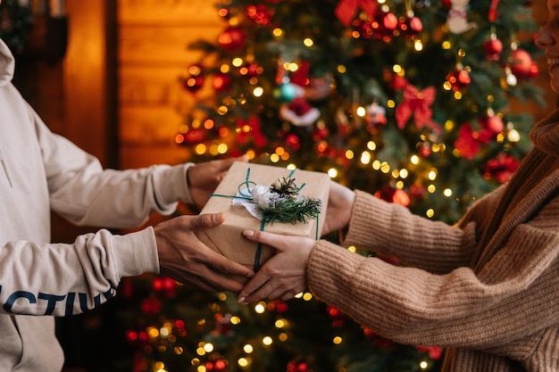 Closeup hands of African American man giving Christmas gift to Caucasian girlfriend