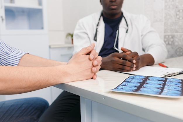 Closeup of the hands of an AfricanAmerican doctor and patient