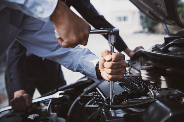 Closeup hands of auto mechanic using the wrench to maintenance car engine