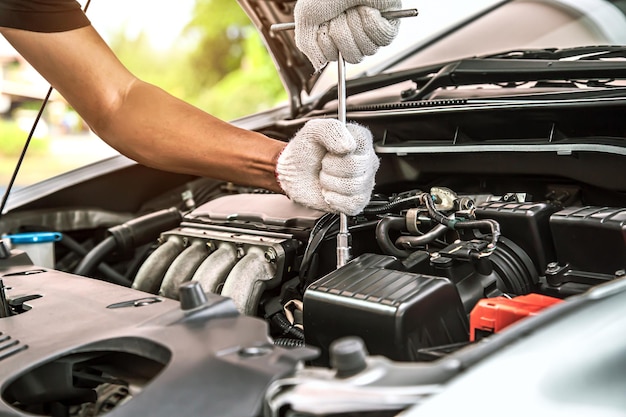 Closeup hands of auto mechanic using the wrench to maintenance car engine