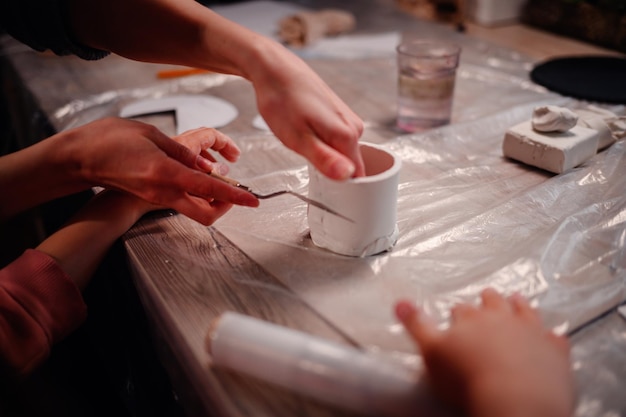 Photo closeup of hands carefully molding clay capturing the essence of tactile learning and artistic expression during a family crafting session