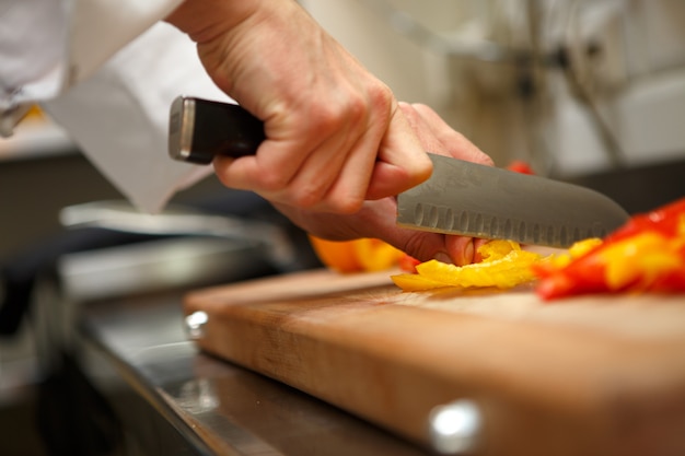 Closeup on hands cutting yellow pepper