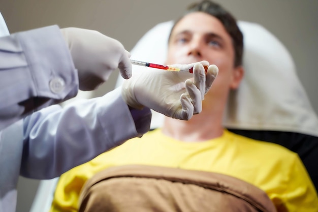 Closeup hands of doctor holds a syringe in preparation to give the patient an injection