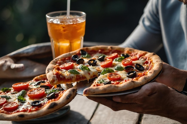 Closeup of hands holding pizza and a drink